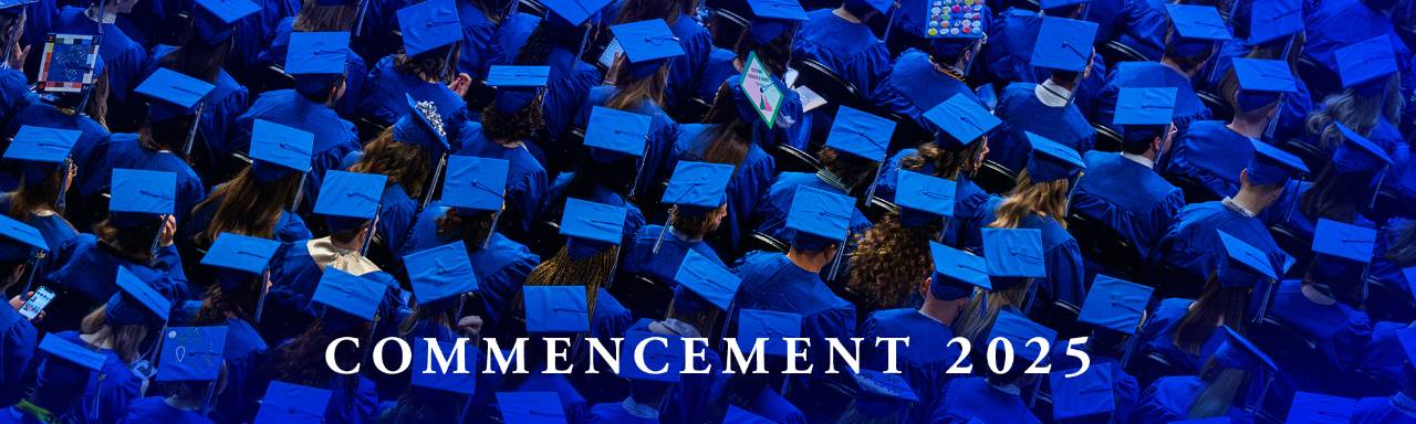 aerial view of hundreds of students wearing their blue graduate caps